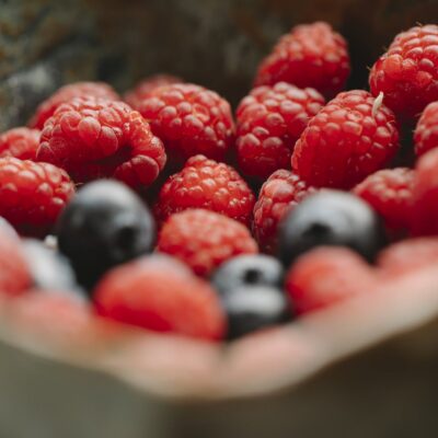 Appetizing ripe raspberries and blueberries in bowl