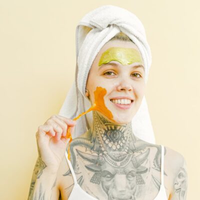 Tattooed smiling woman removing face mask