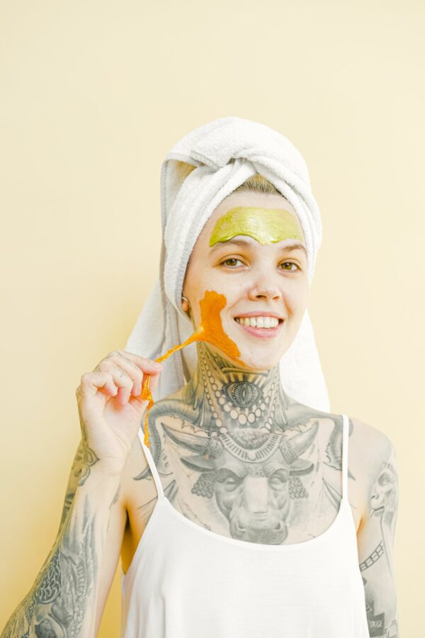 Tattooed smiling woman removing face mask